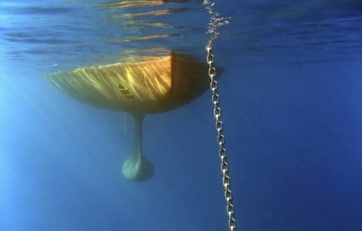 Underwater shot of a sailing yacht behind the anchor chain